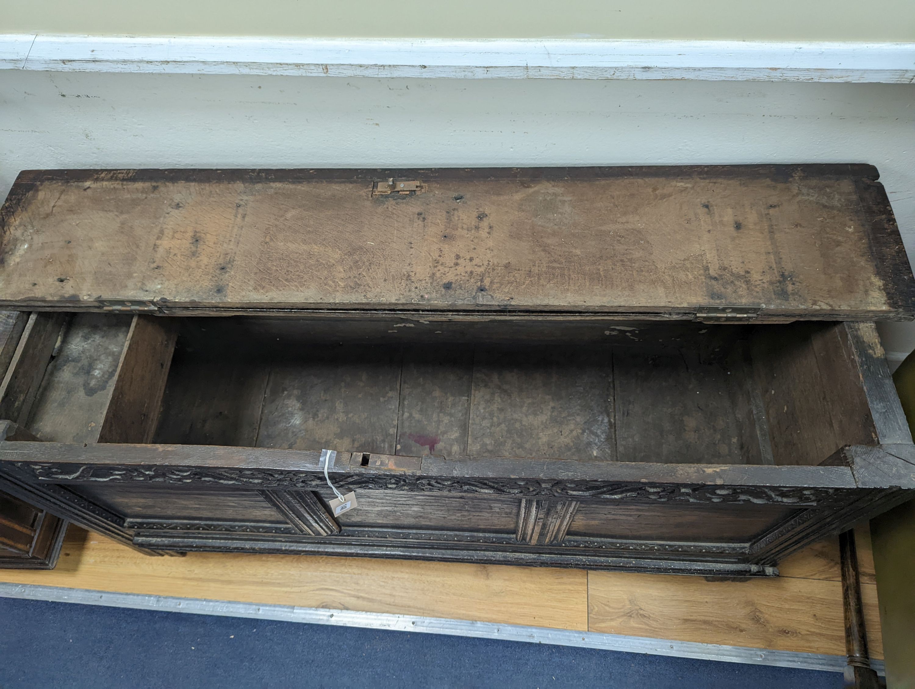 A 17th century panelled oak coffer, (the hinged lid adapted) width 130cm, depth 49cm, height 63cm